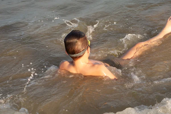 Boy 10 years old swims in the sea on a sunny day