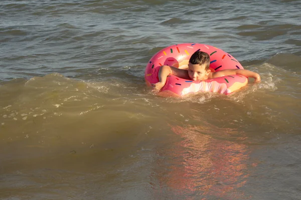 Ein Jähriger Junge Badet Einem Sonnigen Tag Einem Krapfenförmigen Rettungsring — Stockfoto