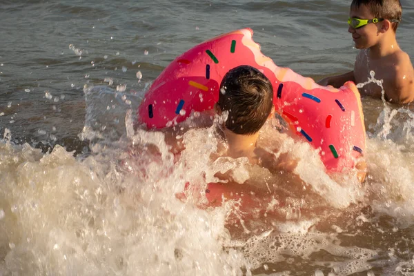 兄弟5と10歳は泳ぎ 海岸近くの海で楽しんでいます 緑色のスイミングゴーグルを身に着けています — ストック写真