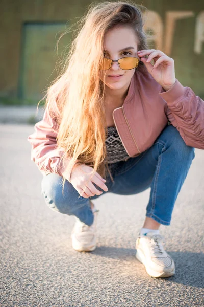 Young beautiful woman on the street. Emotions, people, beauty and lifestyle concept. Street photo of young woman wearing stylish casual clothes. Female fashion concept. Cute teenage girl.