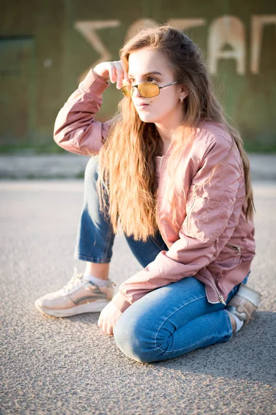 Young beautiful woman on the street. Emotions, people, beauty and lifestyle concept. Street photo of young woman wearing stylish casual clothes. Female fashion concept. Cute teenage girl.