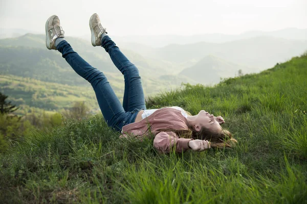 女孩躺在绿色的 Bluberry 领域在 Carpatian 时髦的旅行者甚至女孩躺在草地上 在山上放松 在山顶上的时髦 大气时刻 流浪和旅行概念 — 图库照片