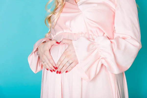 体のケア 妊娠の食事概念 胃にハートの形を形成する女性の手 青色の背景に妊娠中の女性 — ストック写真