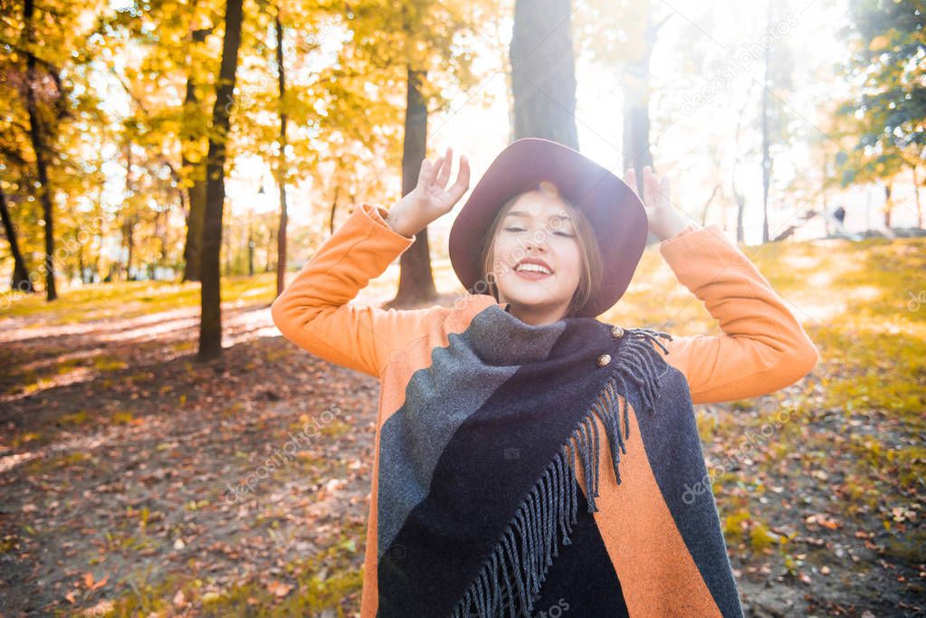 Season and people concept - beautiful happy teen girl having fun with leaves in autumn park. Portrait of a happy and positive beautiful girl