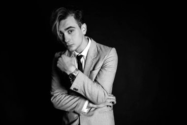 İyi görünümlü bir güzel genç adam kostüm siyah arka plan üzerine yakın çekim portresi. Siyah-beyaz fotoğraf.