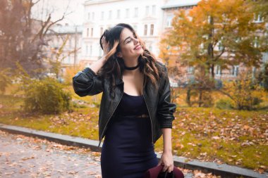 Genç kadın rahat kıyafetler ve siyah deri ceket kentsel şehir arka plan sonbahar portre üzerinde moda. Hippi kız Sokağı'nda poz. Zarif sonbahar giysileri moda uzun saç modeli. vintade şapka.