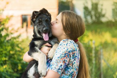 Alman çoban köpeğine sarılan tatlı bir genç kız. Doğada yavru köpeği olan sevimli bir genç kadın..