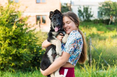 Alman çoban köpeğine sarılan tatlı bir genç kız. Doğada yavru köpeği olan sevimli bir genç kadın..