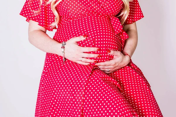 ドレスに妊娠中の女性は 白い背景の上の腹に手を保持します 出産準備 期待のコンセプトです クローズ アップ コピー スペース 屋内で 妊娠の美しい柔らかい雰囲気写真 — ストック写真