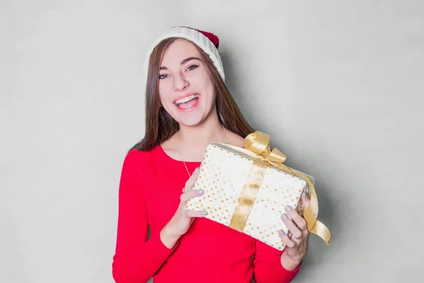 Smiling teenage girl in santa helper hat with many gift boxe on white background. Positive emotional Santa girl. Concept of selling and Christmas shopping. Xmas.