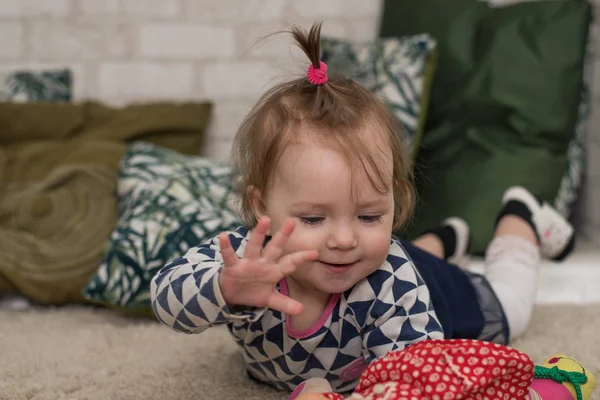 Beautiful baby girl, sucking her thumb and hugging her doll getting ready for bed