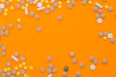 Turuncu arka planda tıbbi renkli haplar, kapsüller ya da tedavi için takviyeler ve sağlık hizmetleri. Yaratıcı bir fikir. - Uyuşturucu. Üzücü. Öl! Hastalık..