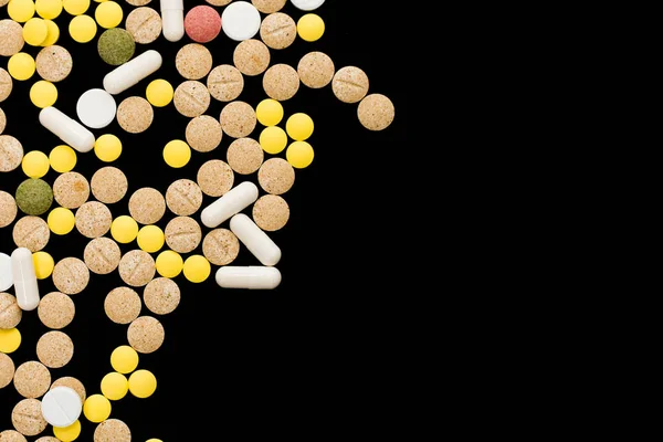 Pillole di medicina farmaceutica assortite, compresse e capsule su sfondo nero. Idea creativa. Droga. Triste. Muori. Malattia . — Foto Stock