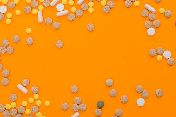 オレンジの背景に治療と医療ケアのための医療カラフルな薬、カプセルまたはサプリメント。創造的なアイデア。薬だ悲しい死ぬんだ病気. — ストック写真
