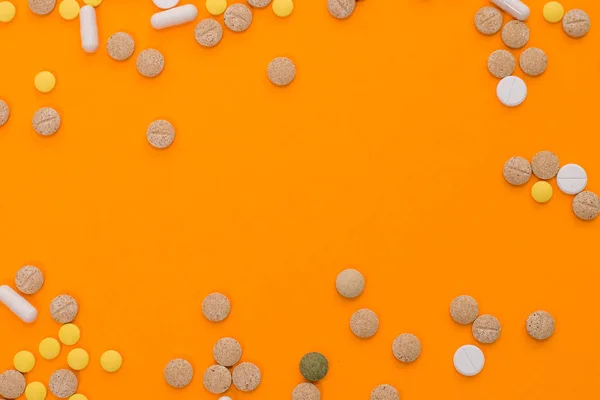 Píldoras coloridas médicas, cápsulas o suplementos para el tratamiento y la atención médica en fondo naranja. Una idea creativa. Drogas. Triste. Muere. Enfermedad . —  Fotos de Stock