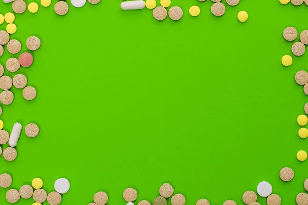 Orvosi színes tabletták, kapszulák vagy kiegészítők a kezelés és az egészségügyi ellátás zöld alapon. Kreatív ötlet. Drogok. Szomorú. Meghalsz. Betegség. — Stock Fotó