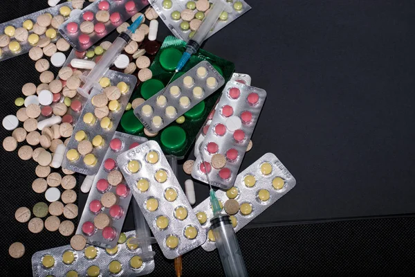 pharmaceuticals antibiotics pills medicine /colorful antibacterials pills on black background /capsule pill medicine. Creative idea. Drugs. Sad. Die. Illness