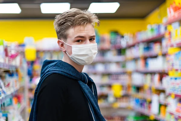 Boy wears protected mask in store. Shopping time during coronavirus outbreak.Boy in a medical mask. Quarantine and protection virus, flu, epidemic COVID-19. Coronavirus quarantine.