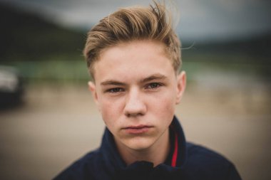 Avrupalı okul çağındaki yeşil gözlü çocuk doğrudan kameraya bakıyor, yakın plan.