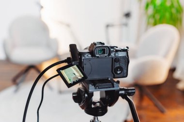 Açık mikrofon ve görüşme alanına odaklanmış kamera ile donatılmış çağdaş bir stüdyoda bir podcast röportajı gerçekleştiriliyor..