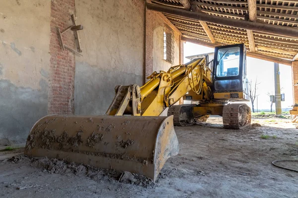 bir çiftlik döken altında park etmiş bir buldozer fotoğrafı