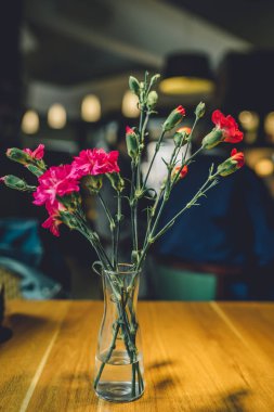 Karanlık bir arka planda masada karanfil