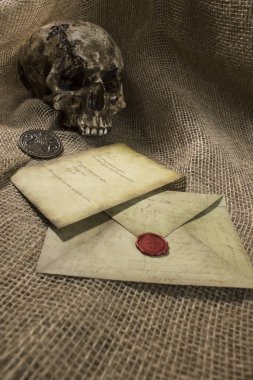 Bir çuval bezi arka plan ile bir mektup ile hasarlı kafatası
