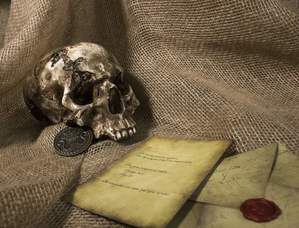 Bir çuval bezi arka plan ile bir mektup ile hasarlı kafatası — Stok fotoğraf