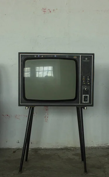 Старый телевизор с четырьмя ногами в углу винтажной комнаты — стоковое фото
