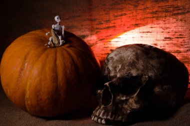 Kahverengi tekstil arka planında kırmızı ışığı olan insan kafatası, Cadılar Bayramı dekorasyon kavramı