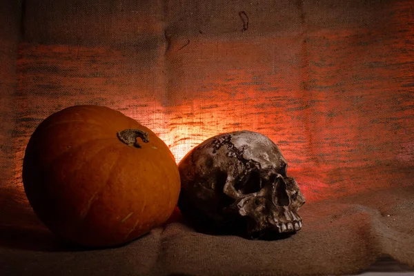 Craniul uman cu lumină roșie pe fundal textil maro, conceptul de decorațiuni de Halloween — Fotografie, imagine de stoc