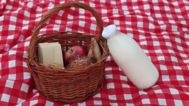 Piknik sepetini süt şişesiyle kapat. Kadın elleri piknik sırasında sepetten süt şişesi alıyor.
