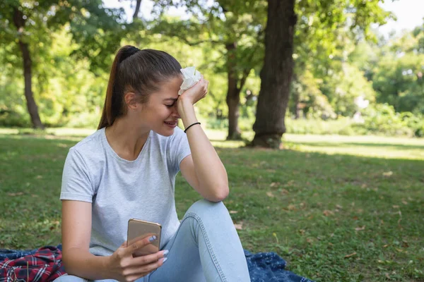 Joven Mujer Triste Sentada Parque Sosteniendo Teléfono Móvil Llorando Porque — Foto de Stock