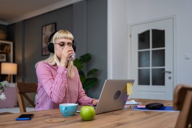 Ek iş para, ikinci iş konsepti. Öğrenci kredisini ödemek için internetten internet üzerinden çalışan genç bir üniversite öğrencisi, kira için para biriktiren, seyahat tatilinde ev videosundan çalışan bir kadın.
