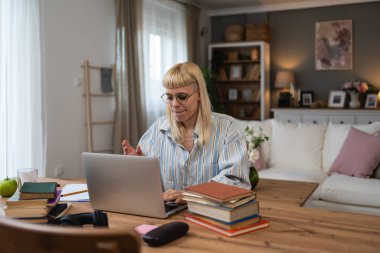 Ek iş para, ikinci iş konsepti. Öğrenci kredisini ödemek için internetten internet üzerinden çalışan genç bir üniversite öğrencisi, kira için para biriktiren, seyahat tatilinde ev videosundan çalışan bir kadın.