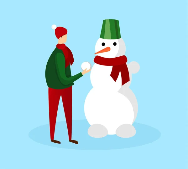 Teenage Boy in Warm Winter Clothing Making Snowman
