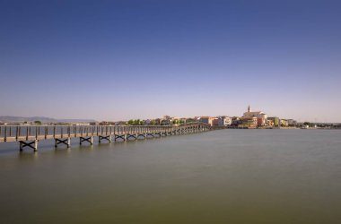 Lesina Gölü'nde geçit ve arka planda köyün görünümü