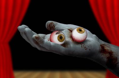 Bir çift göz küresi tutan zombi el