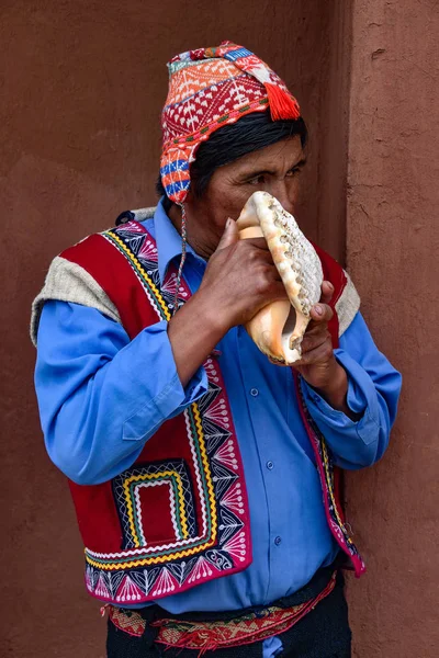 Vale Sagrado, Cusco, Peru - Um homem quéchua indígena sopra em uma concha — Fotografia de Stock