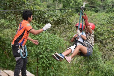 Junin, Peru - Chanchamayo bölgesindeki bir nehirden kayarak geçen maceraperest turistler