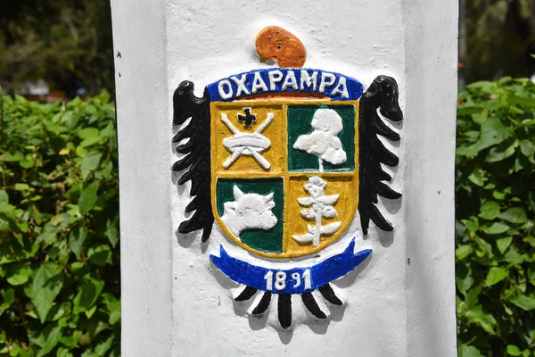 Oxapampa, Perú - El escudo de armas de Oxapampa pintado en un poste de luz en la Plaza de Armas — Foto de Stock