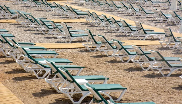 Turizm sezonu açıldı, çok az turist geldi, çok sayıda boş güneşlik ve plaj sandalyesi var. Konyaalti Plajı, Antalya, Türkiye.