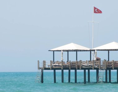 Shingle Plajı ve Türkiye'deki aquamarine su küçük ahşap iskele. 