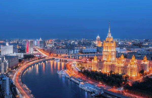 Yüksek bir yerden şehrin manzarası. Moskova dönüm noktası. Hotel ve Flotilla Radisson Royal. Novy Arbat, Moskova nehri ve gemileri. Şehir trafiği, akşam aydınlatması.