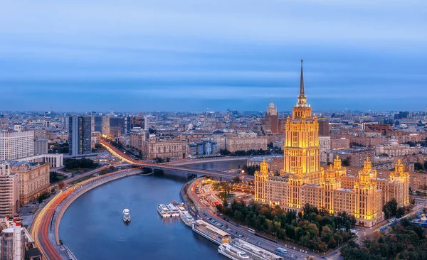 Yüksek bir yerden şehrin manzarası. Moskova dönüm noktası. Hotel ve Flotilla Radisson Royal. Novy Arbat, Moskova nehri ve gemileri. Şehir trafiği, akşam aydınlatması.