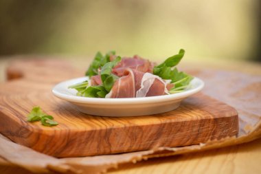 Tabakta prosciutto ve roka ile rulo var.