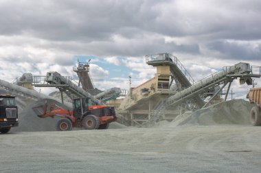 Döküntü kamyonlara ezilmiş taş yükleme