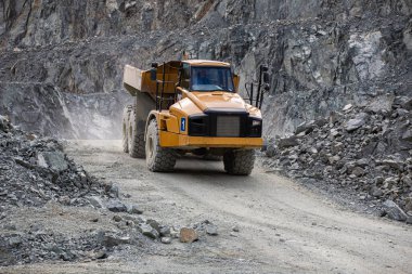 Ağır yük kamyonu taş ocağında yol boyunca ilerliyor.