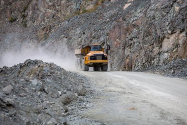 Ağır yük kamyonu taş ocağında yol boyunca ilerliyor.