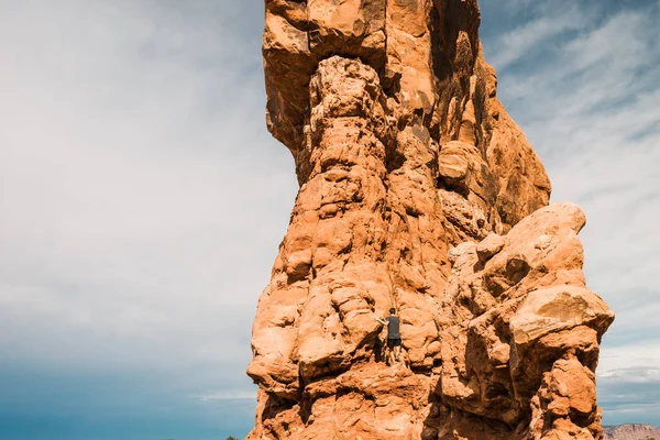 Man standing on strange geological formation against blue sky